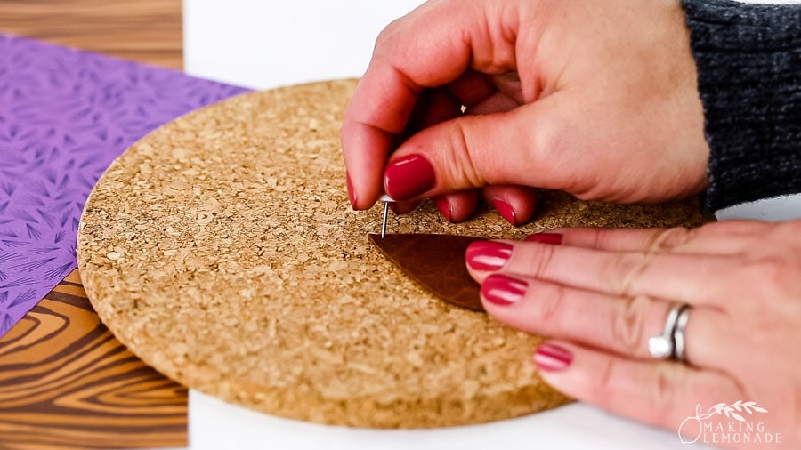 Using a pin to mark the hole for DIY leather earrings