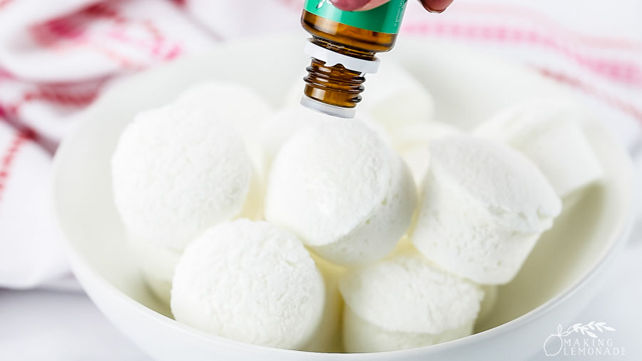 Adding essential oils to shower steamers in a bowl