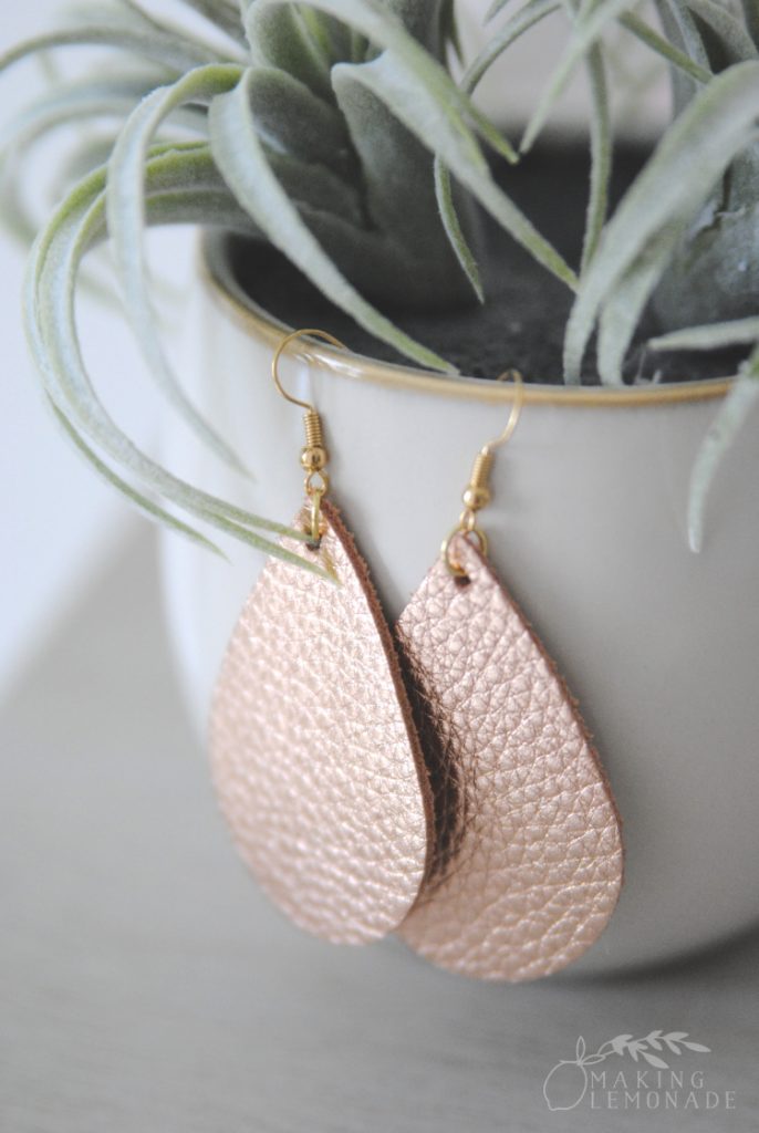 Rose gold leather tear drop earrings on a potted plant 